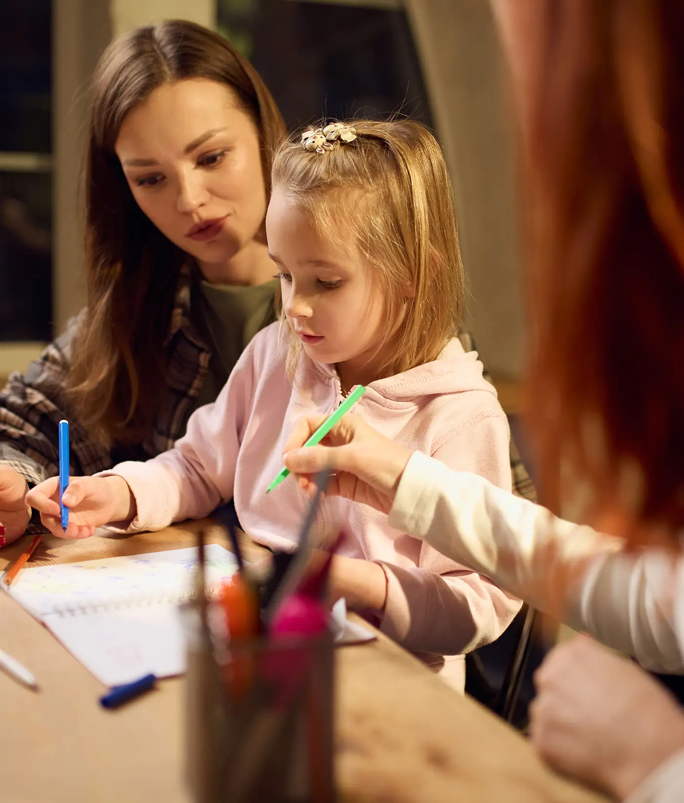 Parent and child working together with support from a Hilltop staff member during a supervised family or mentoring session.