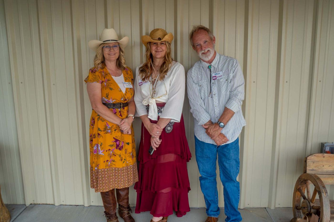 Three people standing inside, smiling