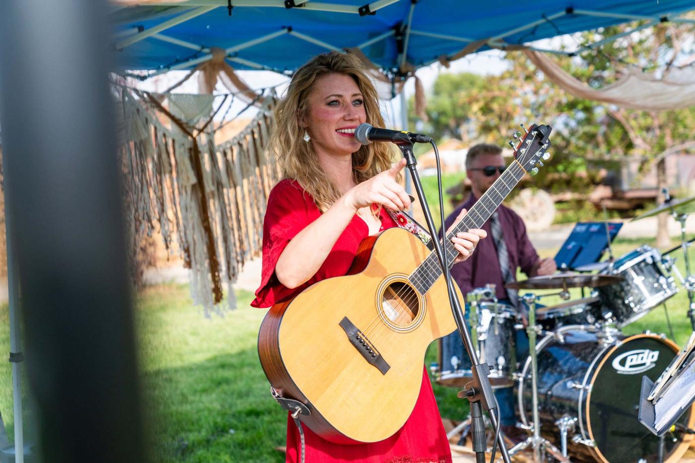 woman singing and playing guitar outside