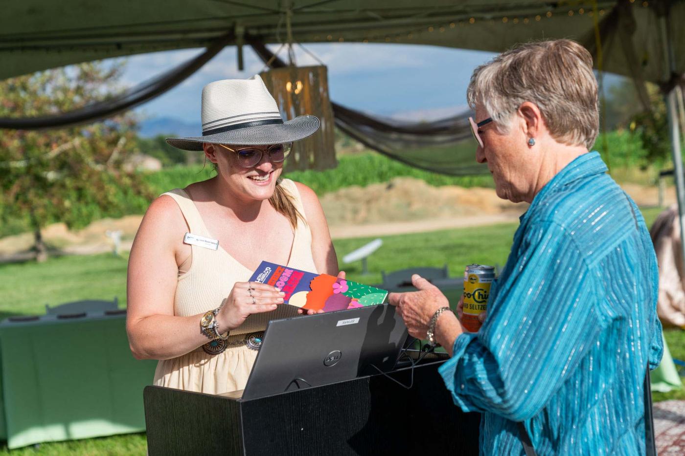 A registration attendant going over the program with a guest