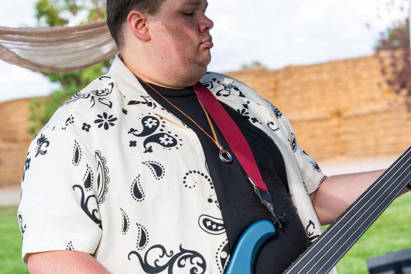 Man playing bass guitar outside