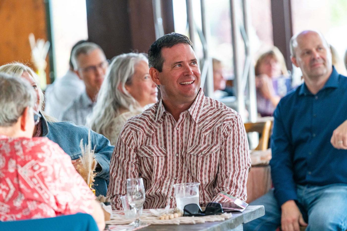 Man smiling in dining room, looking at stage